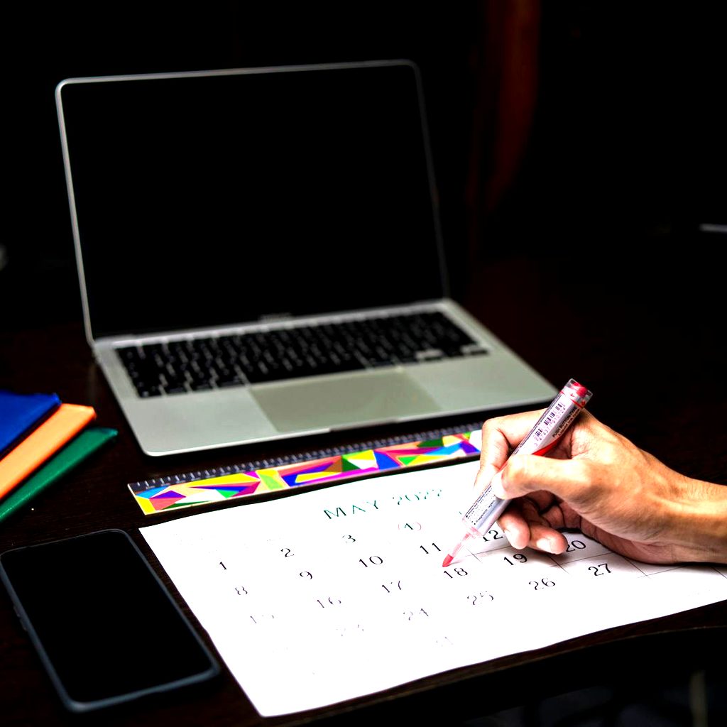 Persona segna una data sul calendario per pianificare ferie e permessi in azienda